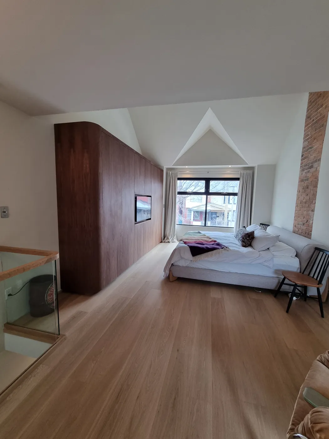 Renovated primary bedroom with walnut millwork and a vaulted ceiling