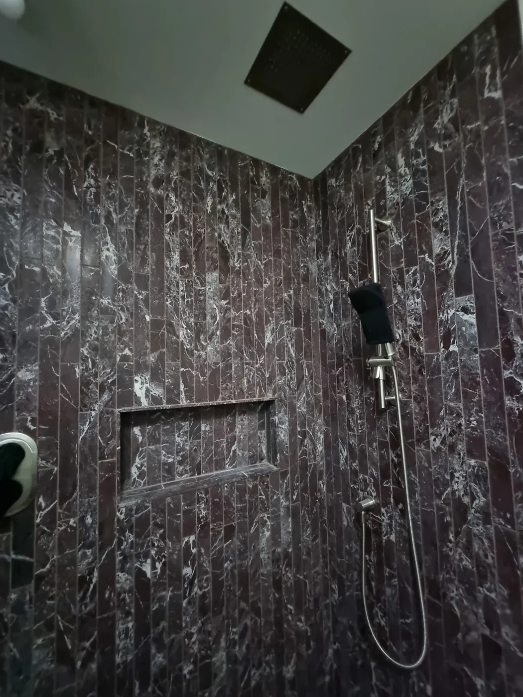 Finished bathroom with a marble rainfall shower and frameless glass